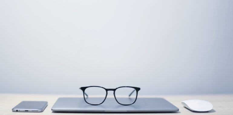 pair of glasses on top of a folded laptop